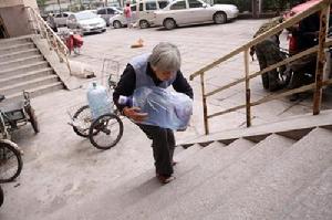 高美運正在吃力地搬運桶裝水